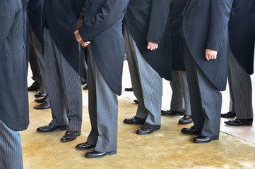 Men wearing the same tail coats at an official ceremony - obrazy, fototapety, plakaty