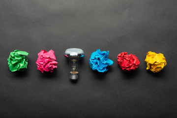 Lightbulb and crumpled colorful paper balls