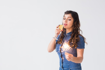 People, celebration and holiday concept - Lovely woman with sparkler and glass of champagne over white background with copy space