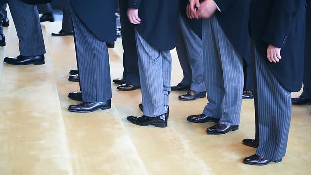 Men wearing the same tail coats at an official ceremony. Dress code concept.