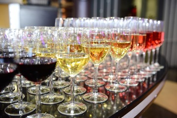 Rows of full champagne, sparkling wine and red wine glasses. Dining, drink. Catering service concept.