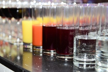 Rows of full juice and sparkling water glasses. Dining, drink. Catering service concept.