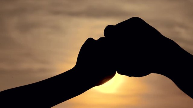 teamwork concept. of a human hand with bumping fist. Friends Friendship Fist Bump Togetherness Concept. father lifestyle and son teamwork hands silhouette at sunset