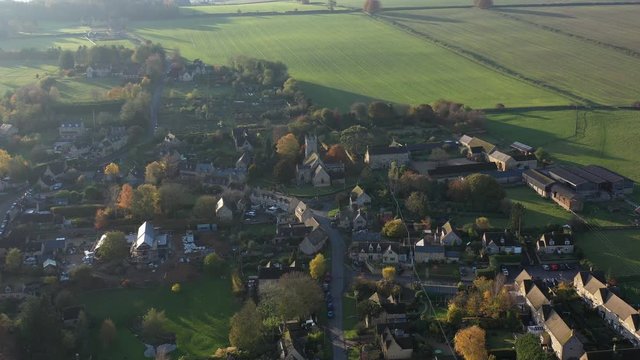 Aerial orbit view of Longborough, a small village near Moreton-In-Marsh revealing sunset and landscape in the Cotswolds Area Of Outstanding Natural Beauty, UK