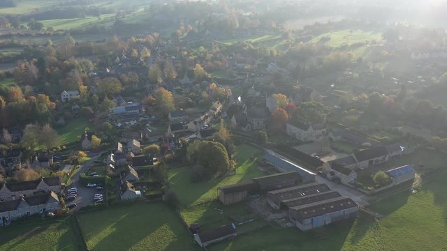 Wide aerial orbit shot of Longborough, a small village near Moreton-In-Marsh in the Cotswolds Area Of Outstanding Natural Beauty, UK