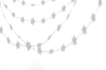 Organic drop shadow of a festive garland of stars on a white wall, overlay effect for photo and mockups.