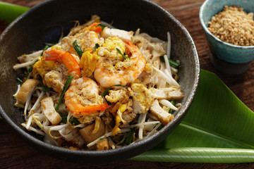 Thai traditional food: Still life of Pad Thai, stired noodles with shrimps, egg served with lime,vegetable. Pad Thai is popular on street food, Thailand, Clean food good taste concept.