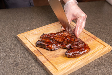 food, delicious and craft concept - Man cutting horse meat steak