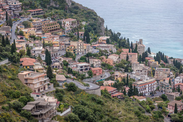 Naklejka premium Aerial view on buildings on slopes of Taormina city seen from Castelmola, small town on Sicily Island, Italy