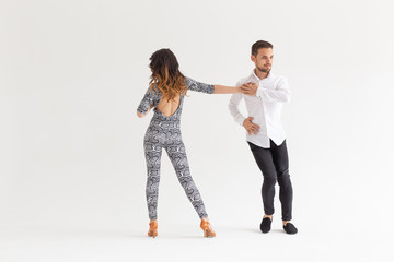 Fototapeta premium Social dance concept - Active happy adults dancing bachata together over white background with copy space