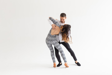 Young couple dancing social latin dance bachata, merengue, salsa. Two elegance pose on white background with copyspace