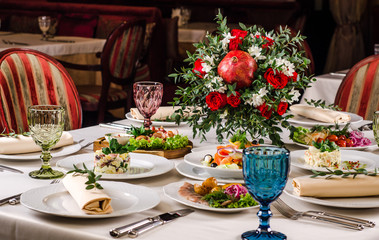 Beautiful restaurant interior table decoration for wedding or event. Flower Wedding Table Decoration, Autumn colors. European food in a restaurant setting. Table set for party.