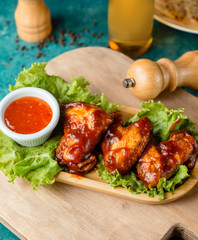chicken wings in ketchup sauce served with sweet chili sauce