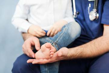 the pediatrician examines the child's feet, the dermatologist treats the heels, foot and heel massage.Concept of examination and treatment of children