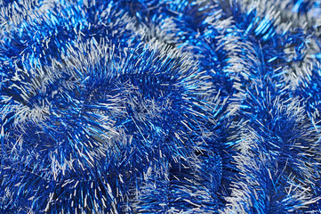 Scattered shiny festive tinsel of blue color. Background