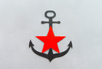 Black anchor with a red star on a gray iron background