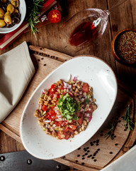 fresh vegetable salad with tomato cubes, walnut, red onion and herbs