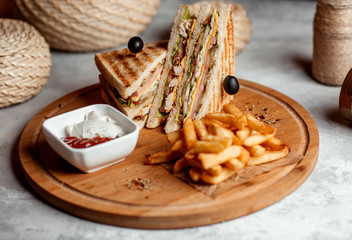 Fototapeta premium club sandwich served with french fries, mayonnaise and ketchup