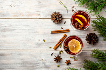 Christmas mulled wine with spices and lemon on wooden rustic background. Top view. Copy space.