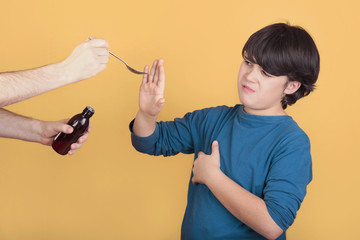 diseased boy does not want to take syrup medicine