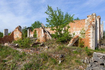 ruins of an abandoned old brick house in the countryside against a blue sky