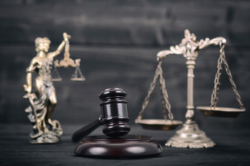  Lady Justice, Scales of Justice and Judge Gavel on a black wooden background.