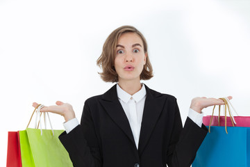 A beautiful business woman in a suit is carrying a colorful shopping bag in a cheerful manner and a happy smile on a white background in the concept of business success and relaxation from work.