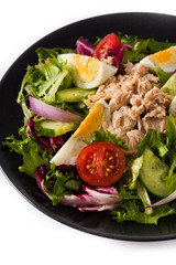 Salad with tuna, egg and vegetables isolated on white background.	