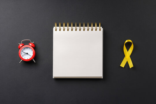 Yellow Cancer Ribbon On Notebook