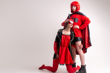 Two sexy girls dressed in halloween costumes posing in studio obver white background.