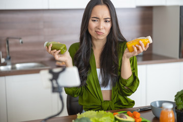 Fototapeta premium Annoyed housewife holding two bottles of sauces