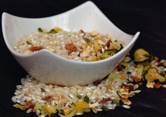 uncooked rice with dry vegetables on a black table