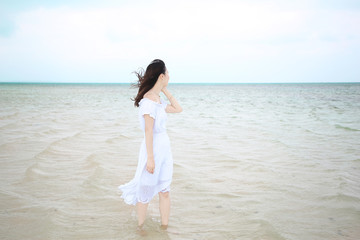 Fototapeta na wymiar 遠浅の海に立つ女性