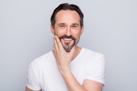 Closeup photo of handsome positive aged man looking mirror toothy smiling hand checking beard after using new shaving gel wear white t-shirt isolated grey color background
