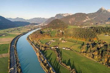 Aerial view of highway interstate road with fast moving traffic near big river in Alps mountains