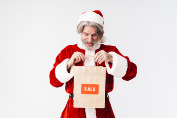 Portrait of surprised old man holding paper bag and smiling