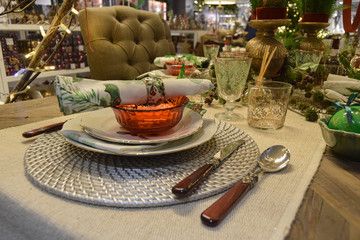 Christmas decoration with white crockery, wood and silver cutlery, flowered glasses and table centerpiece