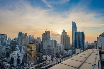 Naklejka na ściany i meble Sunrise at morning at Bangkok metropolis. Building in big city. Shade for shadow orange light.