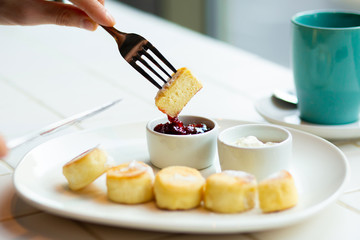 Cottage cheese pancakes with raspberry jam on white plate, close up view. Healthy tasty breakfast Cheesecakes with jam.Traditional Ukrainian dish cottage cheese pancakes served with sour cream.