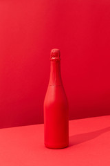 Red painted spray wine bottle on a duotone red background.