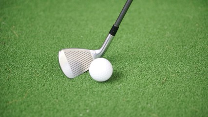 Image of golf iron and golf ball on green grass