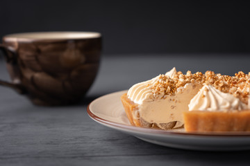 Cut cake basket with caramel near cappuccino closeup.