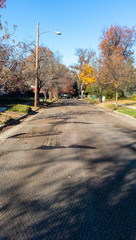 Empty residential neighborhood street scraped and milled in preparation for asphalt repaving.