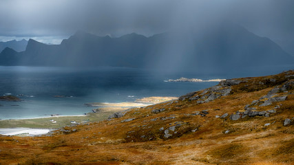 rainy autumn evening   with storm clouds and the rays of the sun on the way up the mountain Ryten of Norway on Lofoten Islands 
