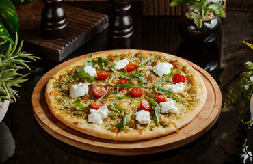 pesto pizza with cherry tomatoes, mozarella and arugula