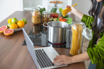 Housewife adding her spaghetti to the pot