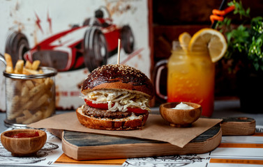 beef burger with tomato, mayonnaise, lettuce served with sauce, fries, orange juice