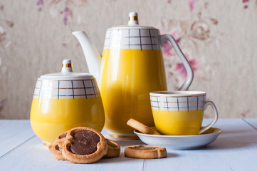 Tasty cookies with chocolate, cup of espresso and a coffee set with a sugar bowl and a spoon