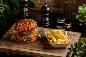 small beef burger served with fried potatoes
