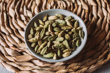 Heap of cardamom seeds in a bowl. Close up view of cardamom seeds as background for design. 